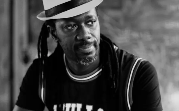 Serious man wearing basketball jersey and white hat