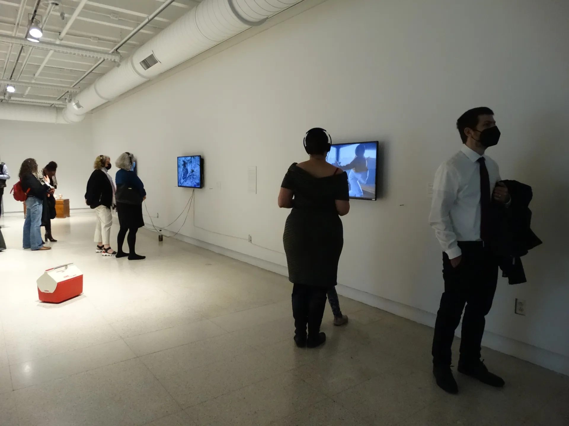 Individuals watching/listening to films on mounted TVs