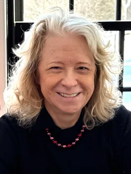Smiling woman in front of windows