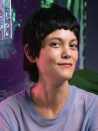 Smiling woman with short hair in front of multicolor backdrop