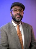 Serious man in suit in front of purple background